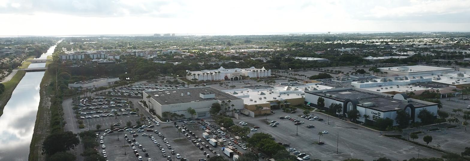 Wide aerial view of a commercial property with the coastline visible in the distance